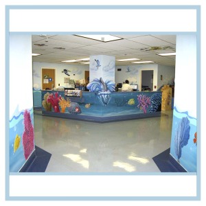 pediatric-unit-entrance-art-healthcare-design-murals-3d-fish-custom-bookcase-nurses-station-dolphin