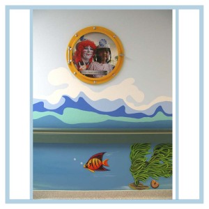 porthole-frame-prints-wall-art-waves-in-hallway-healthcare-design-hospital-decorations-clown